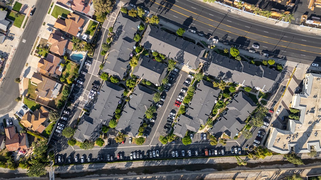 A street view of a residential area with houses and parked cars.