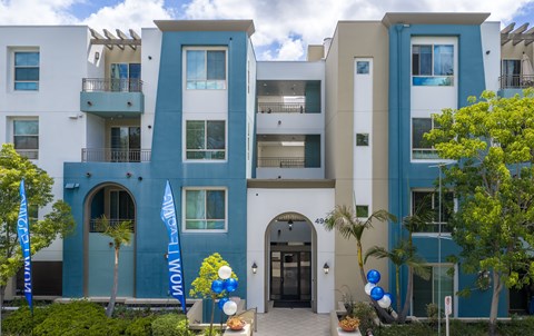 A modern apartment building with balconies and a blue and white facade.