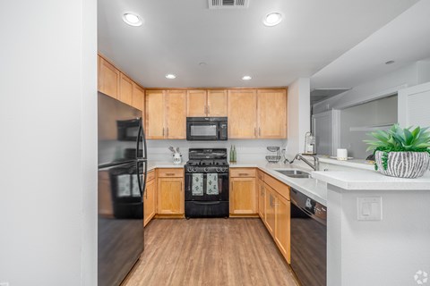 A kitchen with wooden cabinets and black appliances.