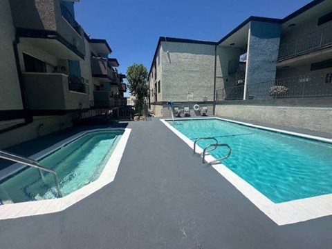 a swimming pool is next to an apartment building