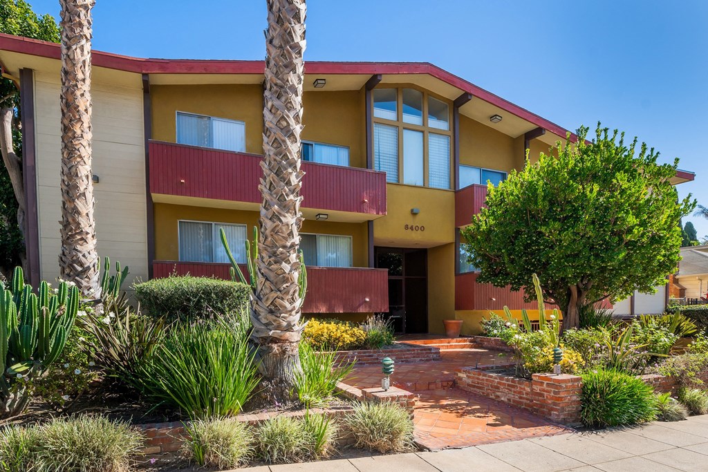 the front of a building with palm trees