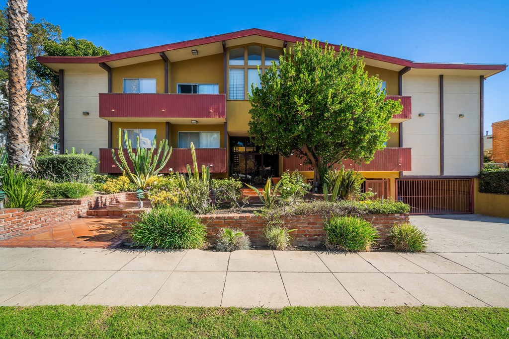 the front of the building with a garden in front of it