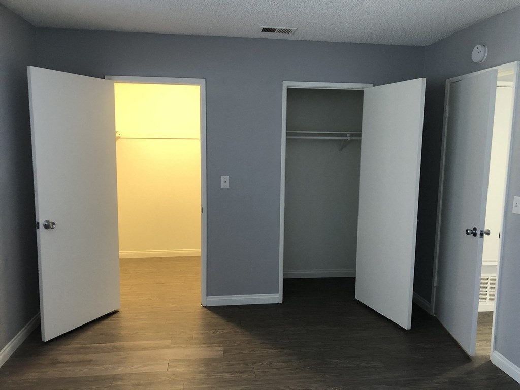 A room with three open doors and a wooden floor.