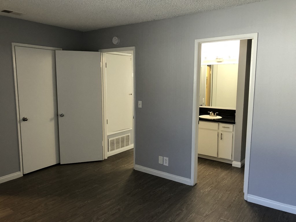 A room with a white door and a mirror on the wall.