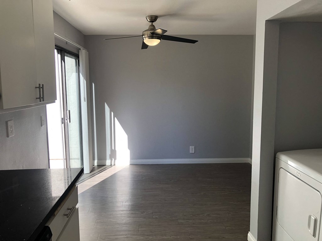 A room with a ceiling fan and a washing machine.