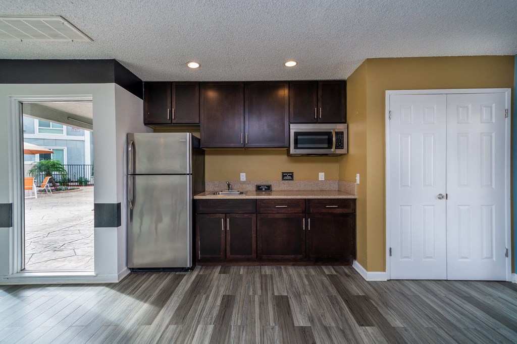a kitchen with dark wood cabinets and stainless steel appliances