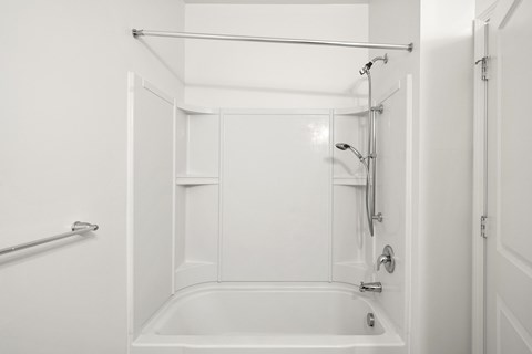 A white bathroom with a tub and shower. at Heritage at Mount Holly, Mount Holly, New Jersey