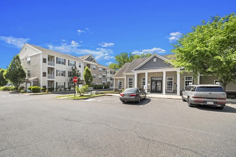 A car is parked in a parking lot in front of a building. at Heritage at Mount Holly, Mount Holly, 08060