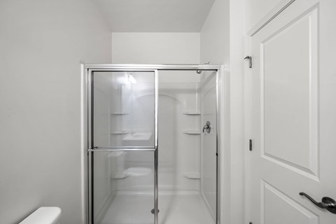 A white bathroom with a walk in shower. at Heritage at Mount Holly, Mount Holly, NJ
