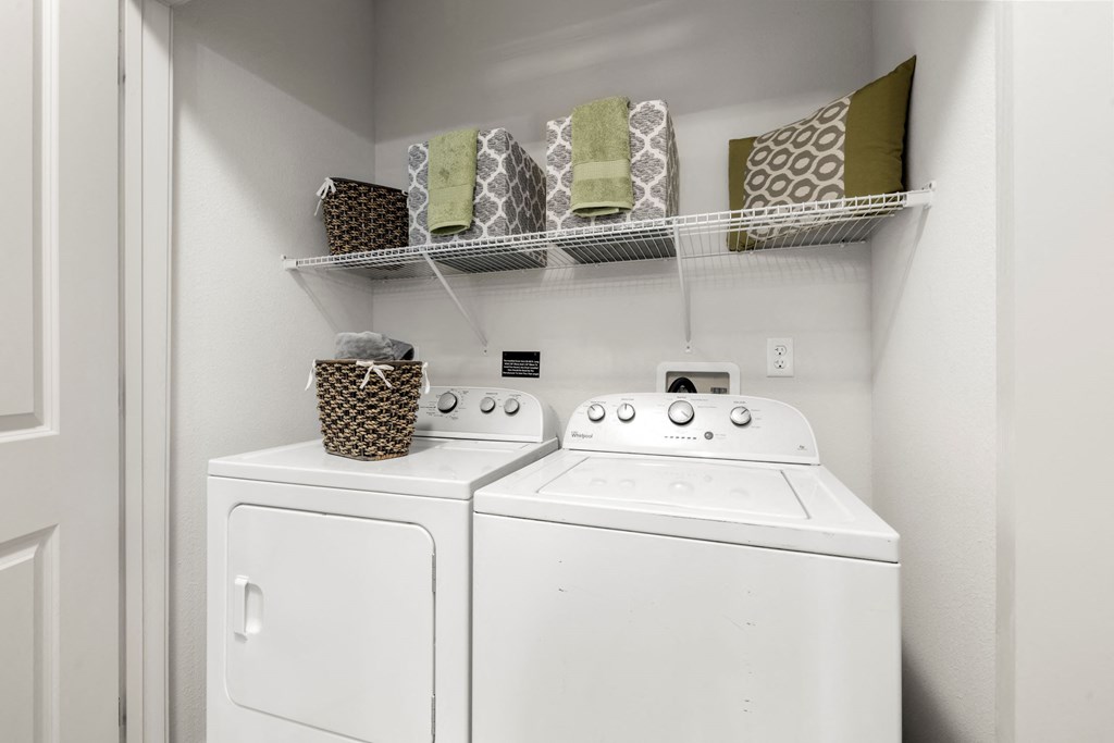 a white washer and dryer in a laundry room with a shelf above it at Pavilion Luxury Apartments, Riverview, 33578
