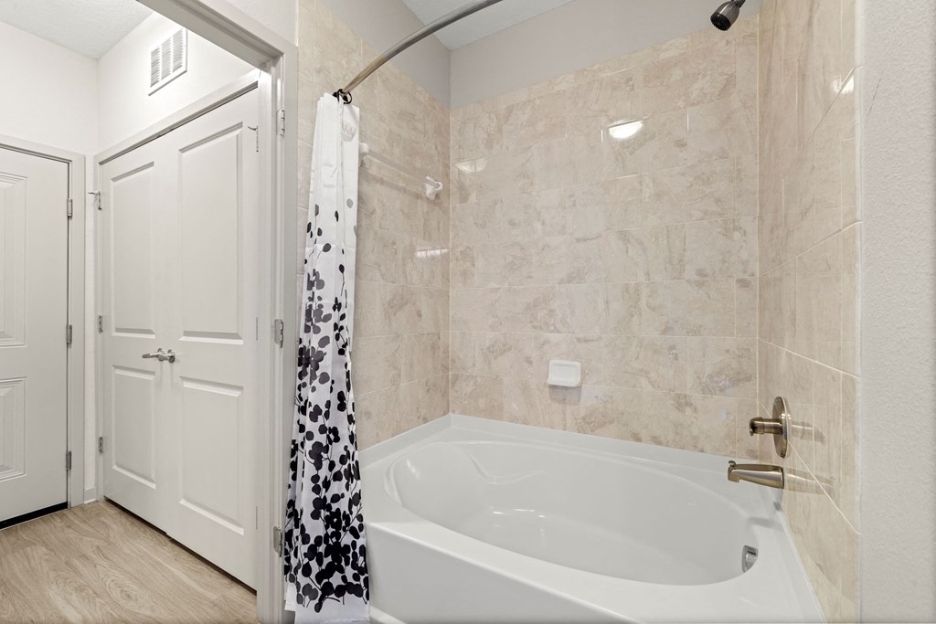 a bathroom with a tub and a shower and a door at Pearce at Pavilion Luxury Apartments, Riverview, FL