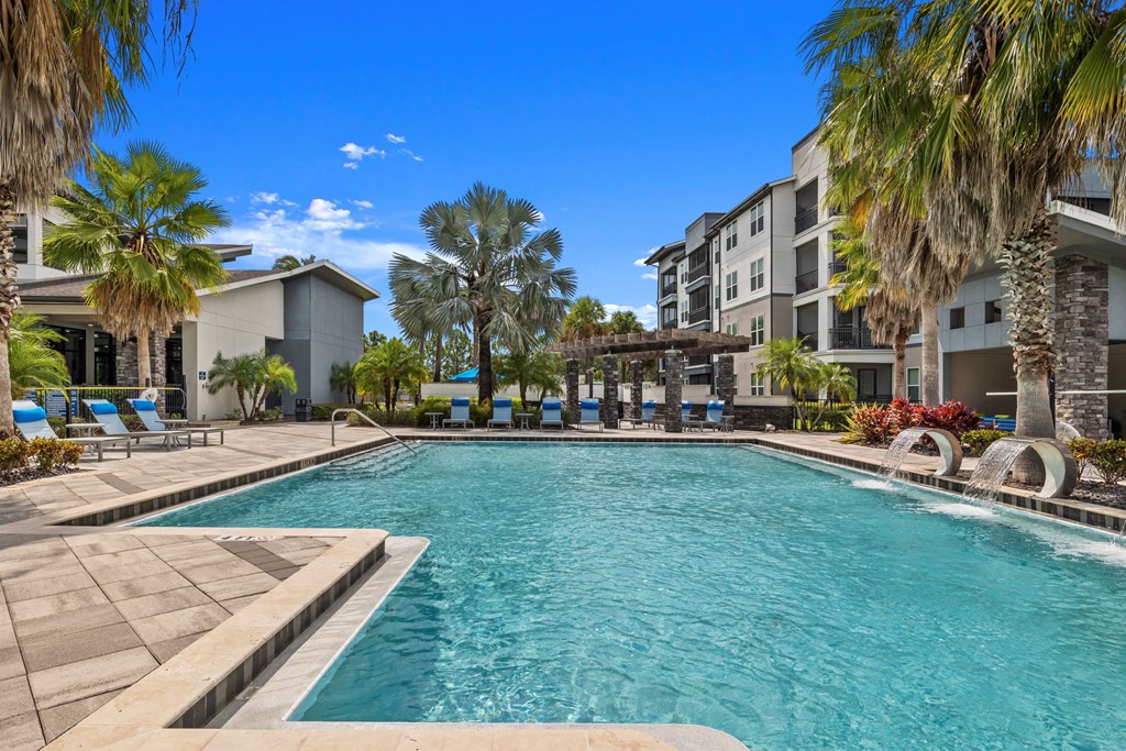 a swimming pool with palm trees in front of an apartment building at Pavilion Luxury Apartments, Riverview, FL, Florida, 33578