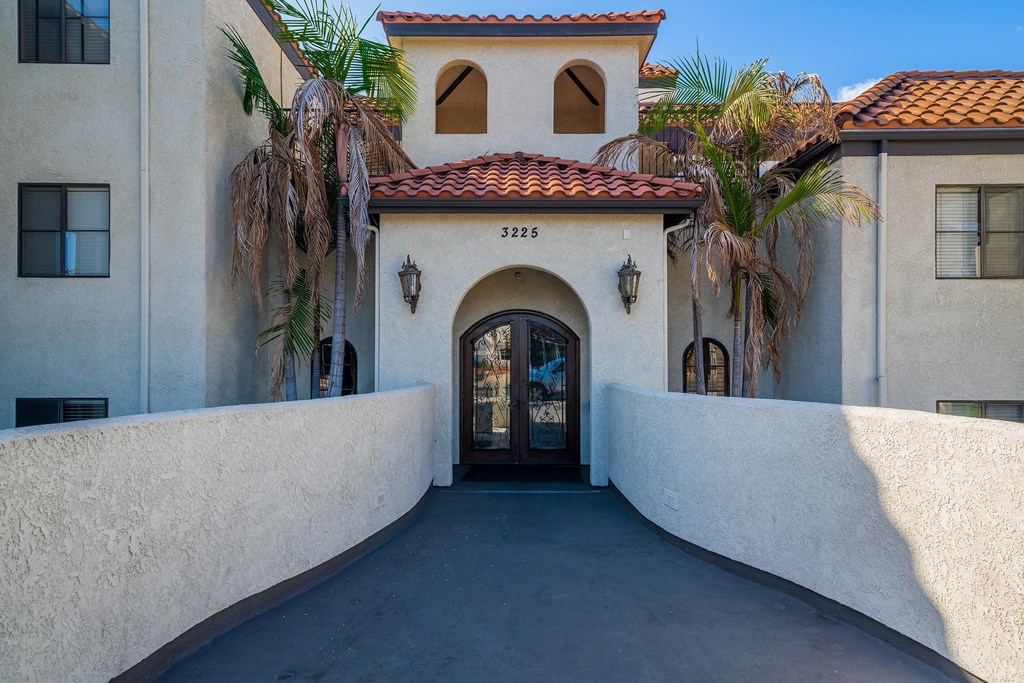 the front door of a building with palm trees