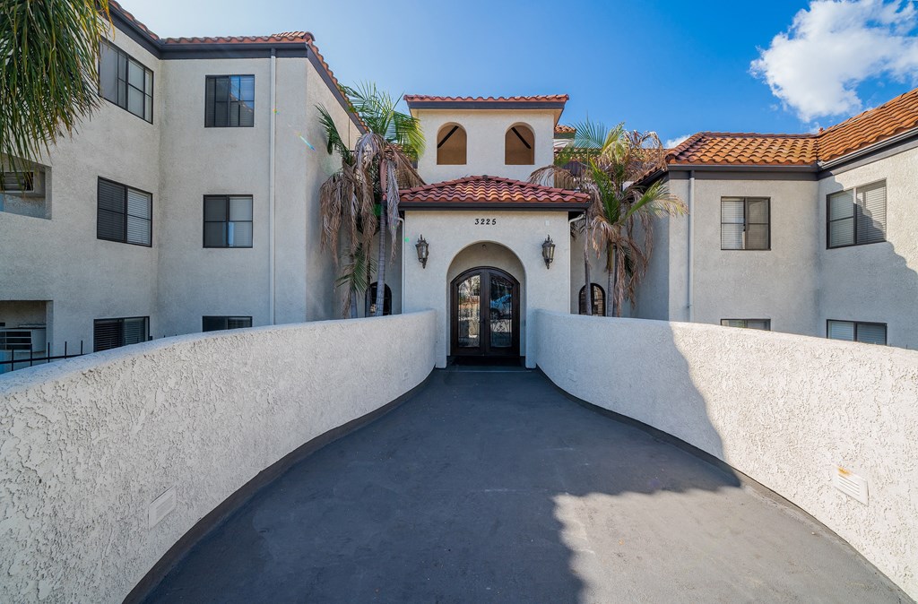 the front entrance of a building with palm trees