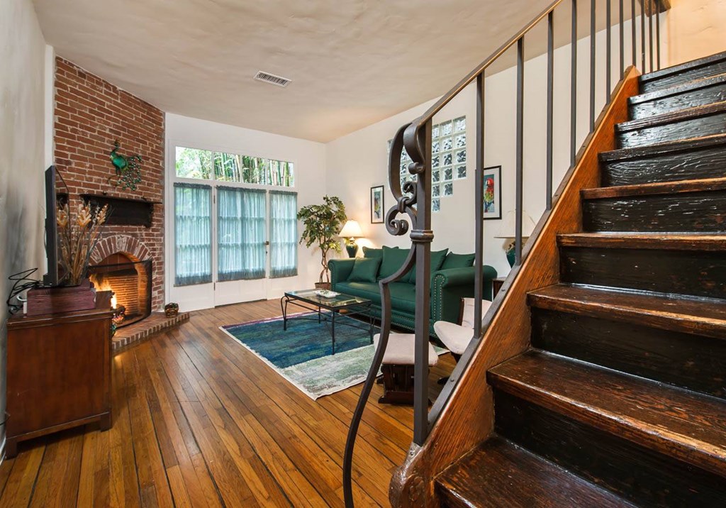 Villa Valentino 1 Living Room2 with view of dark wooden staircase and emerald green couch in the back