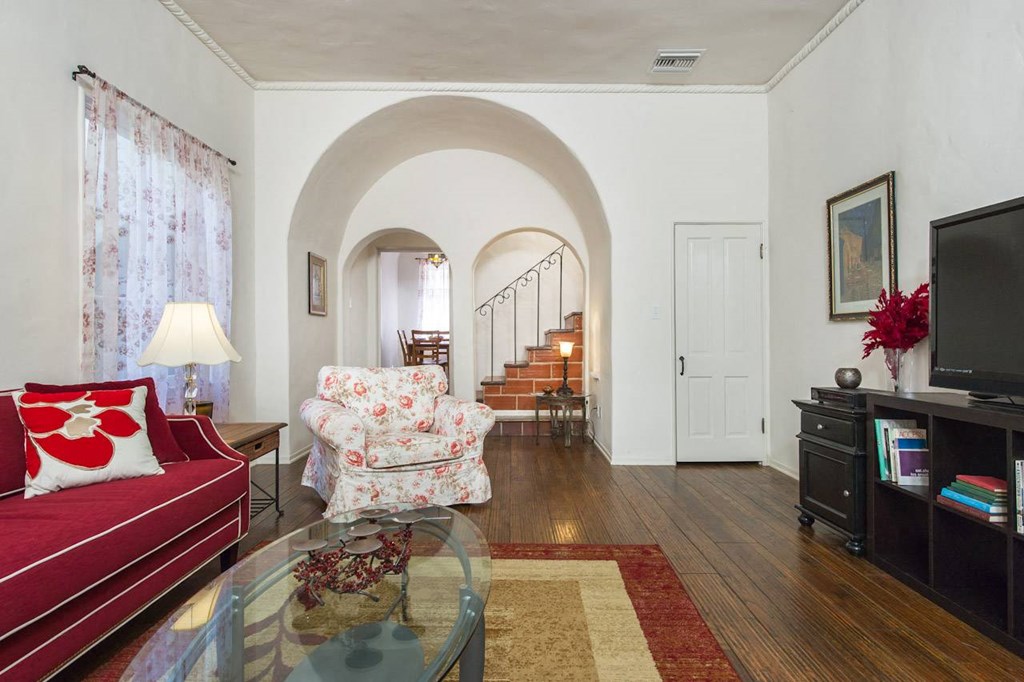 Villa Valentino 14 Living Room with red couch with white trimming facing the TV and the staircase in the back