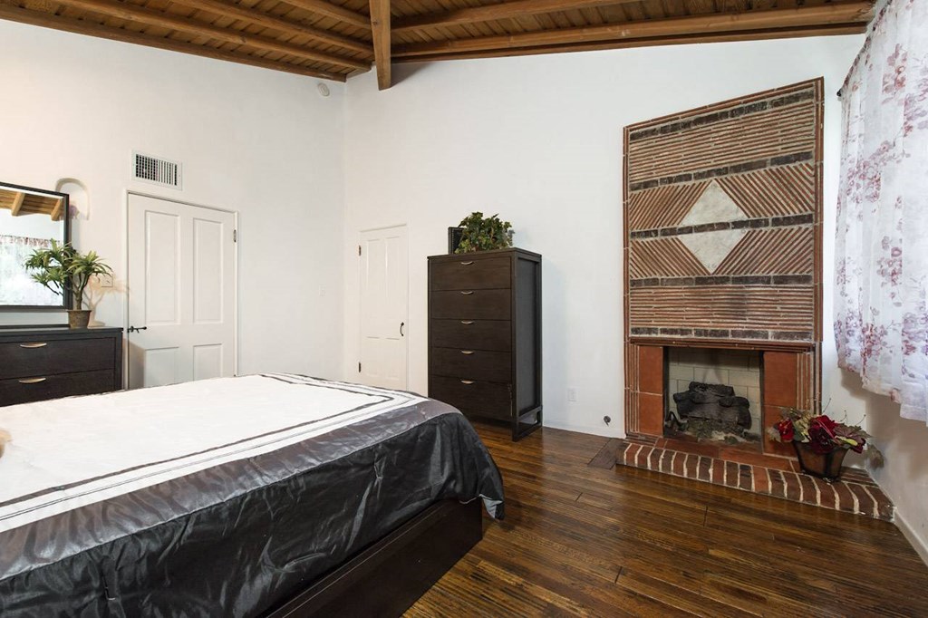 Villa Valentino 14 Master Bedroom with a bed facing the brick fireplace