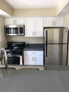 A kitchen with a stove, microwave, and refrigerator.