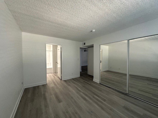 an empty living room with a large mirror and wooden floors