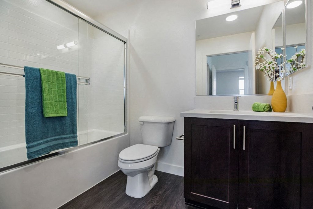 bathroom with toilet, shower, and sink