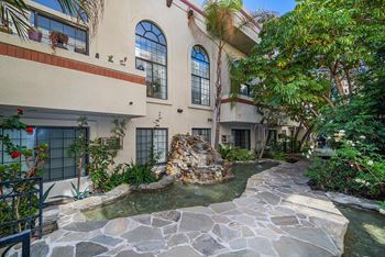 A house with a stone fountain in front of it.