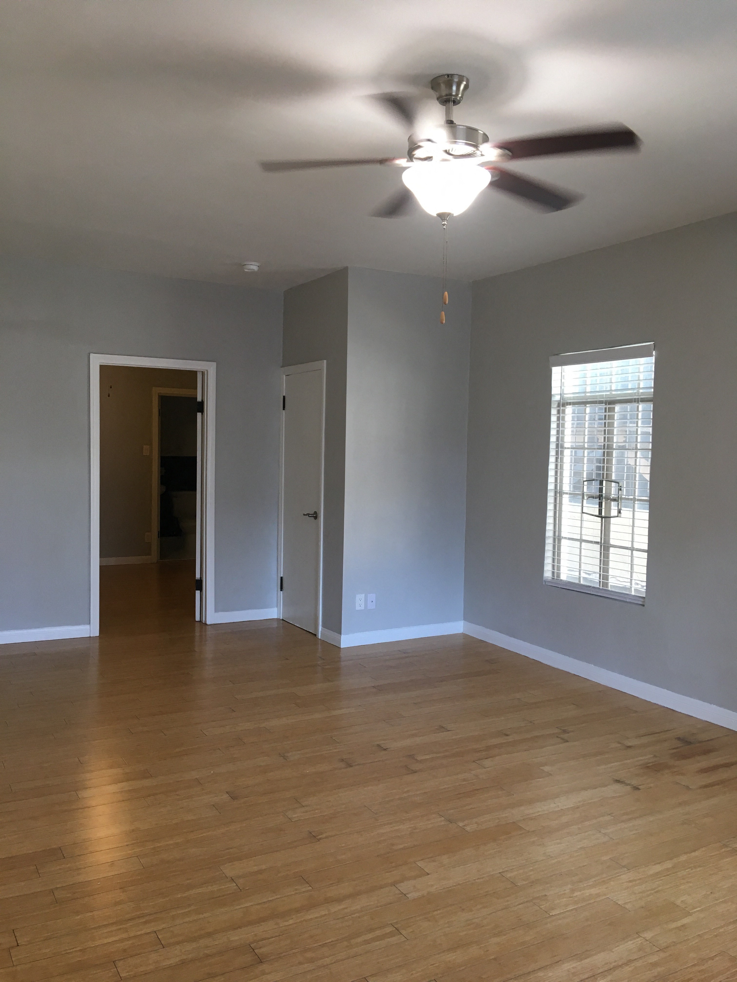 Empty living room with ceiling fan and window