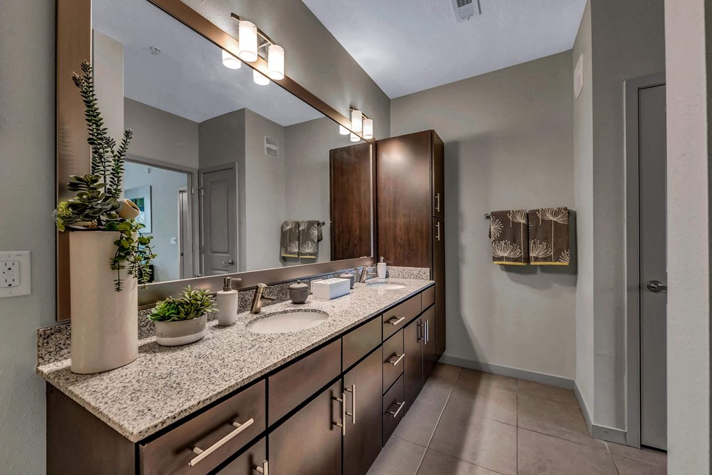 Bathroom with granite counter tops and a large mirror at Pearce at Pavilion Luxury Apartments, Florida, 33578