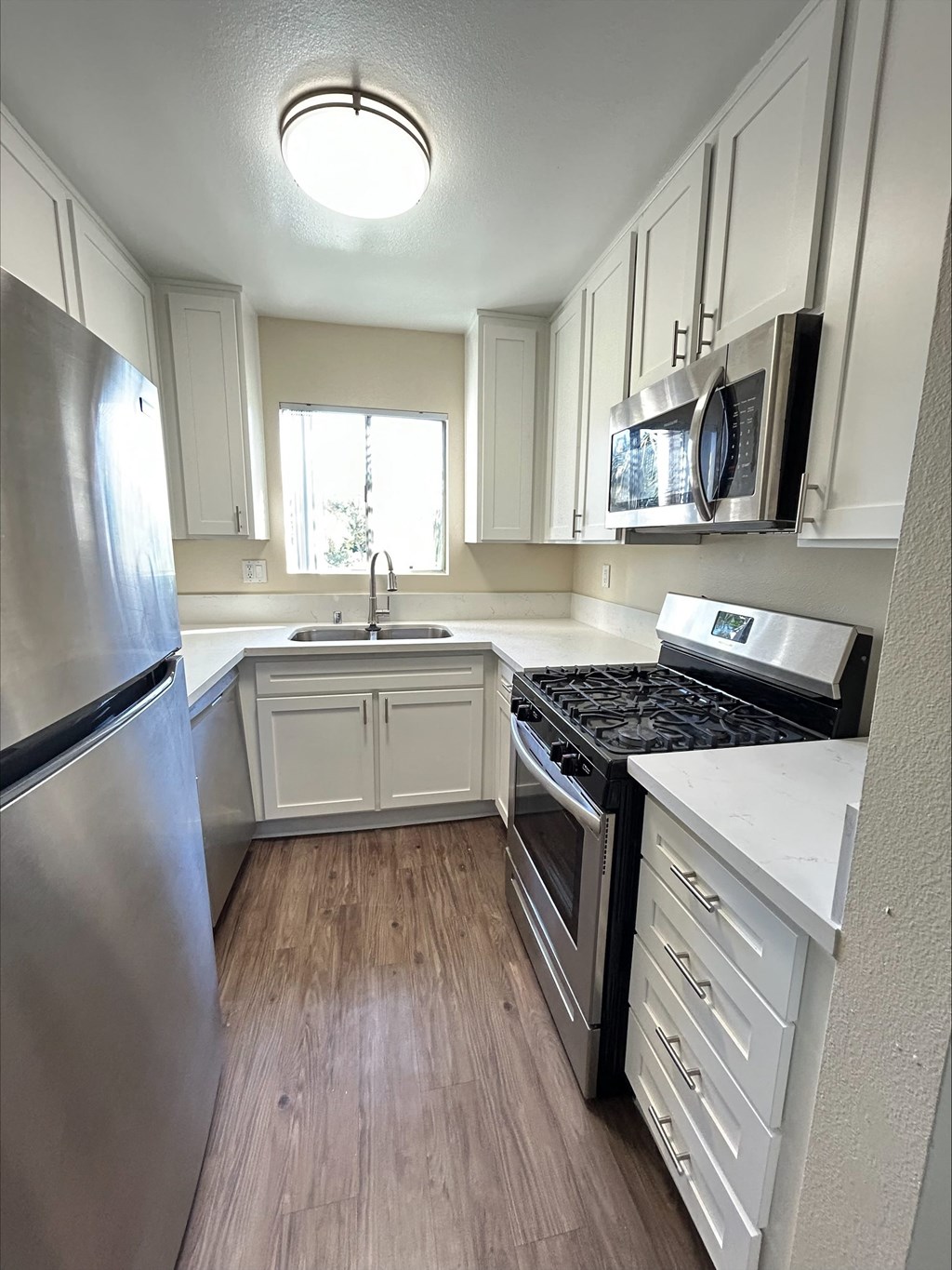 A kitchen with a stove top oven and a refrigerator.