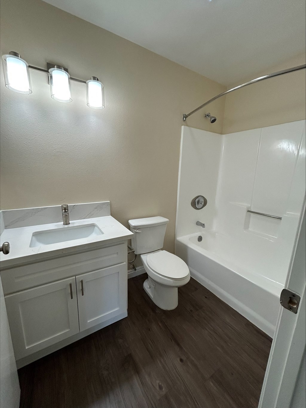 A white bathroom with a toilet, sink, and bathtub.