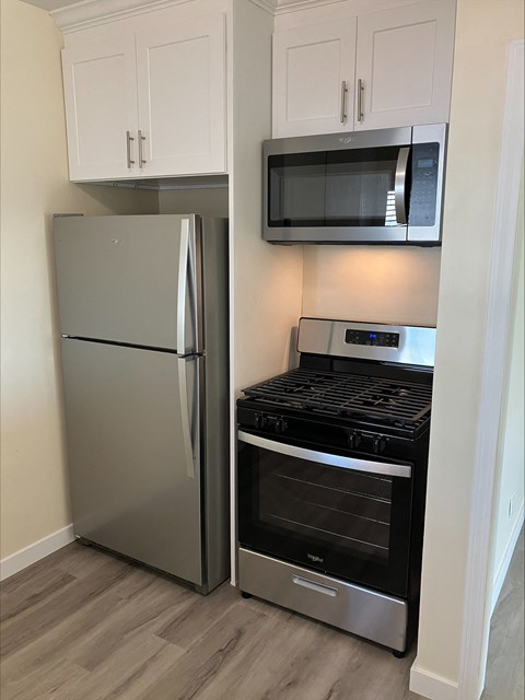 A kitchen with a stainless steel refrigerator and oven.