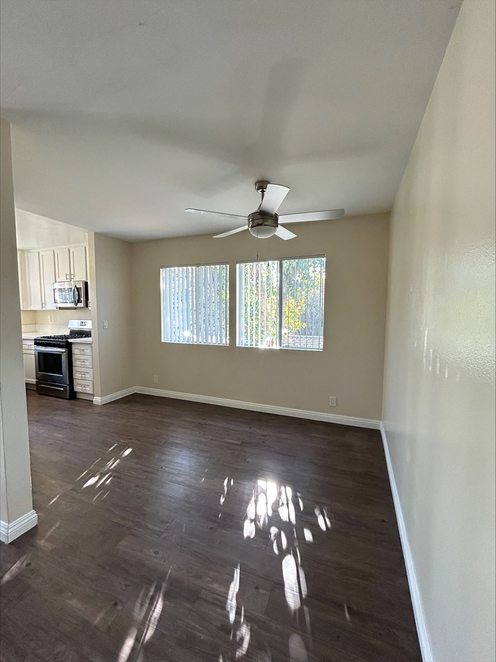 A room with a ceiling fan and wooden flooring.