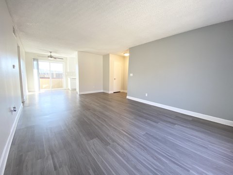 the living room and dining room of an apartment with wood flooring
