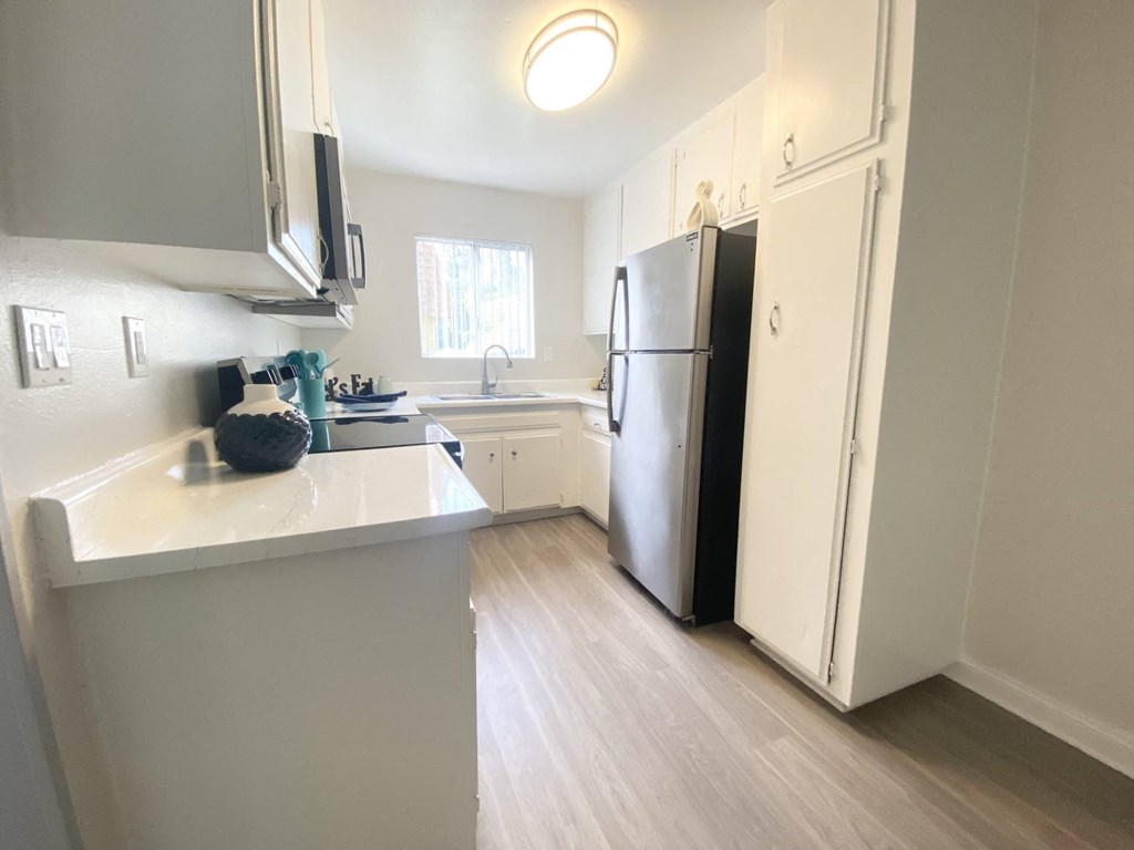 a kitchen with white cabinets and a stainless steel refrigerator