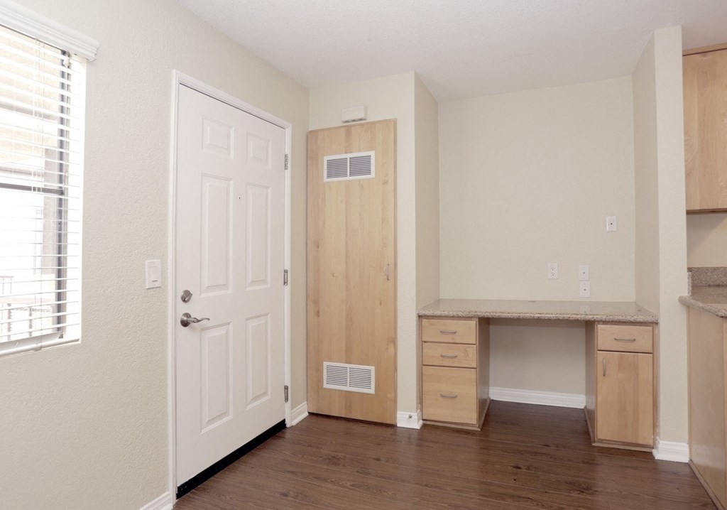 an empty room with a desk and a door