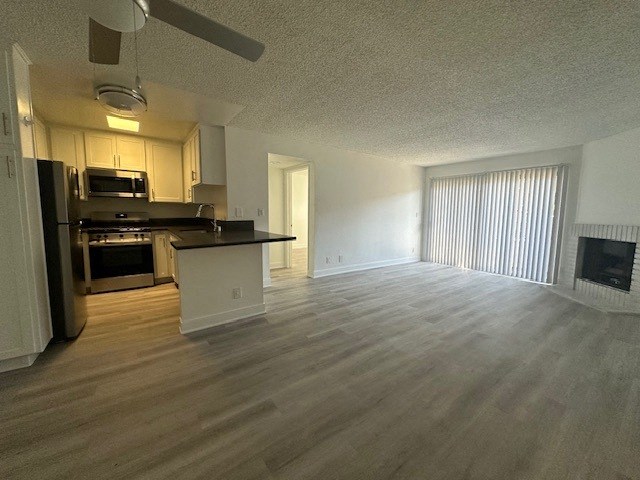 an empty kitchen and living room with wood floors