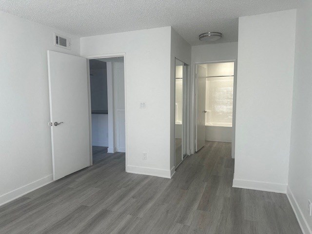 an empty living room with white walls and wood flooring