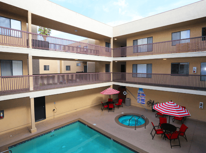 a balcony with a pool and tables with umbrellas