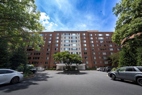 A large red brick building with a parking lot in front.