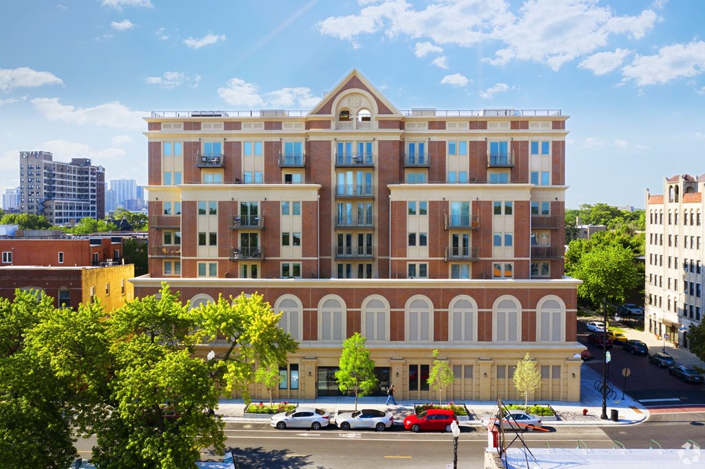 a large brick building with many windows in front of a city street