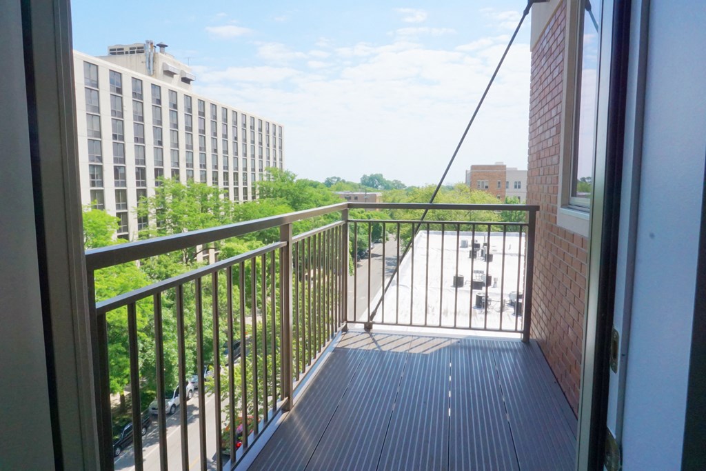 a balcony with a black railing and a city in the background