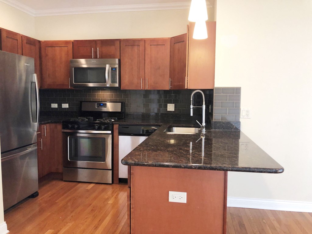 a kitchen with black granite countertops and stainless steel appliances