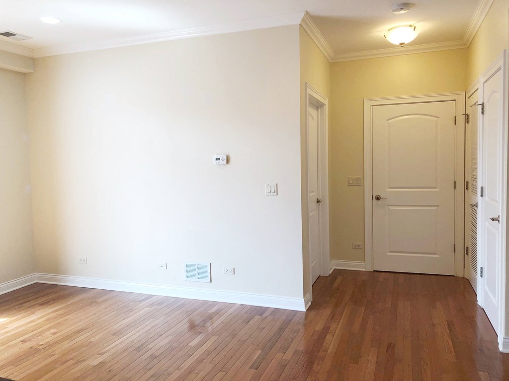 a bedroom with white walls and a wooden floor