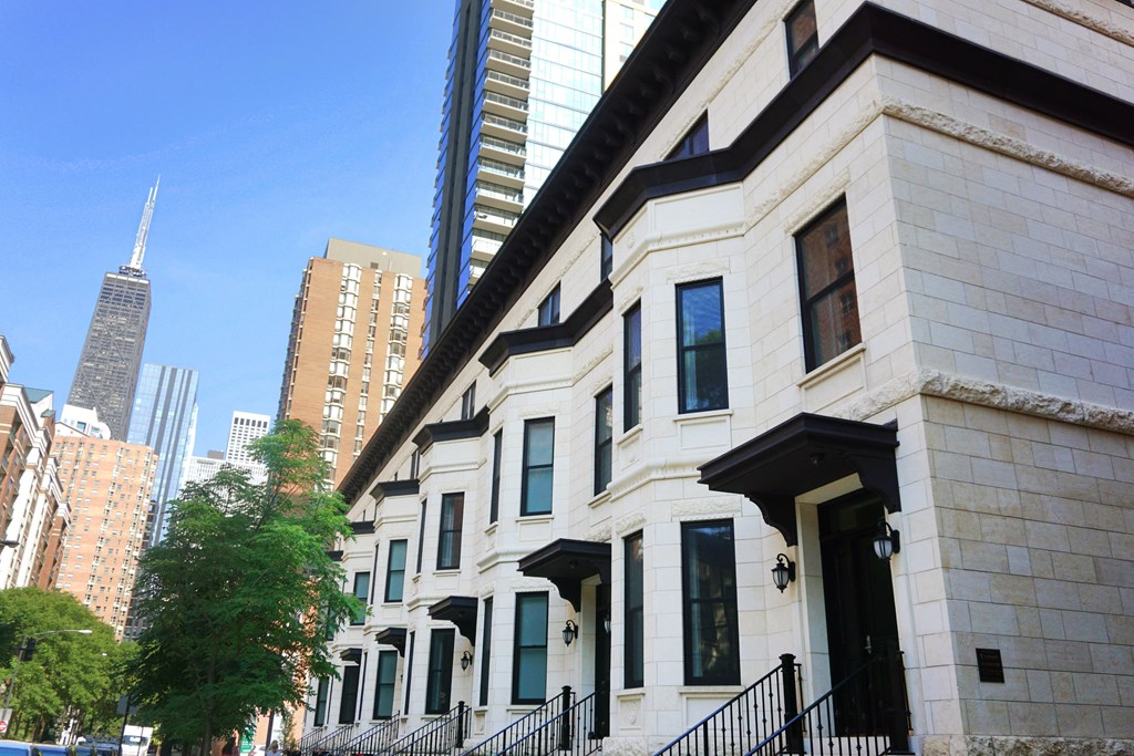 a row of white buildings with skyscrapers in the background