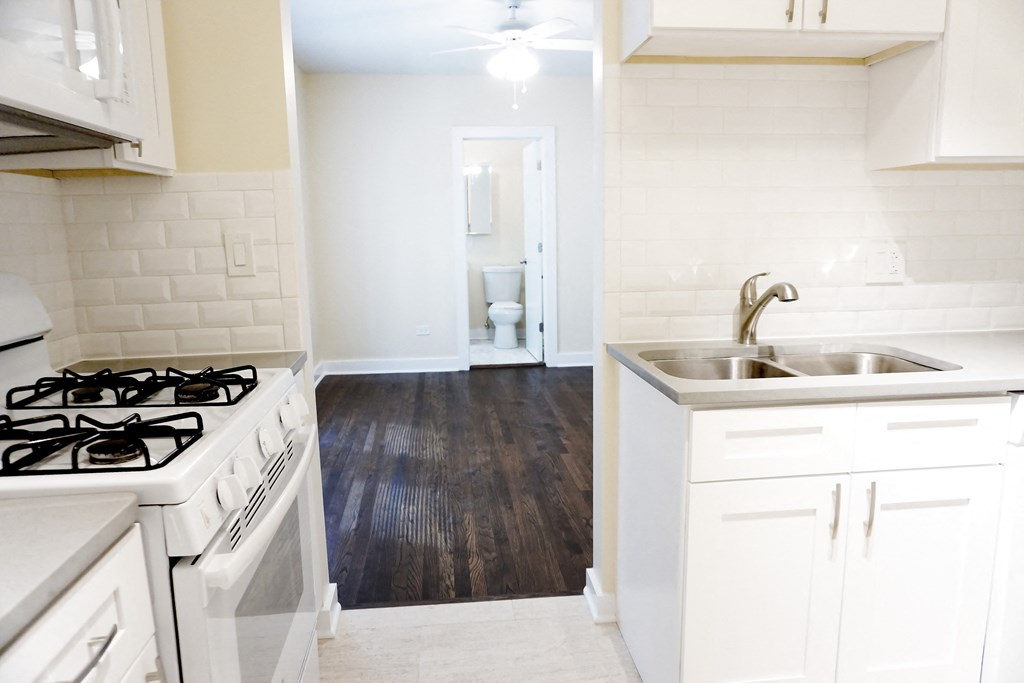a kitchen with white cabinets and a white stove top oven