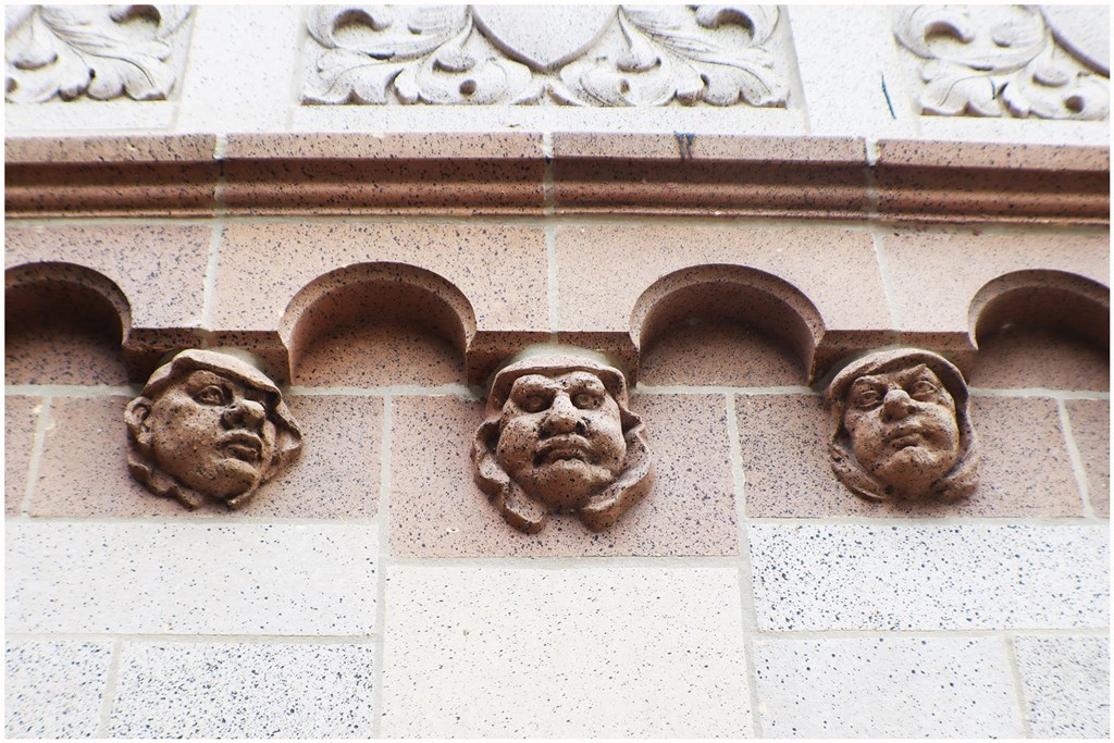 three faces on the side of a building