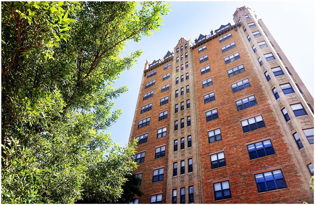 a bride and groom kiss in front of the wrigley building before a soldiers & sailors