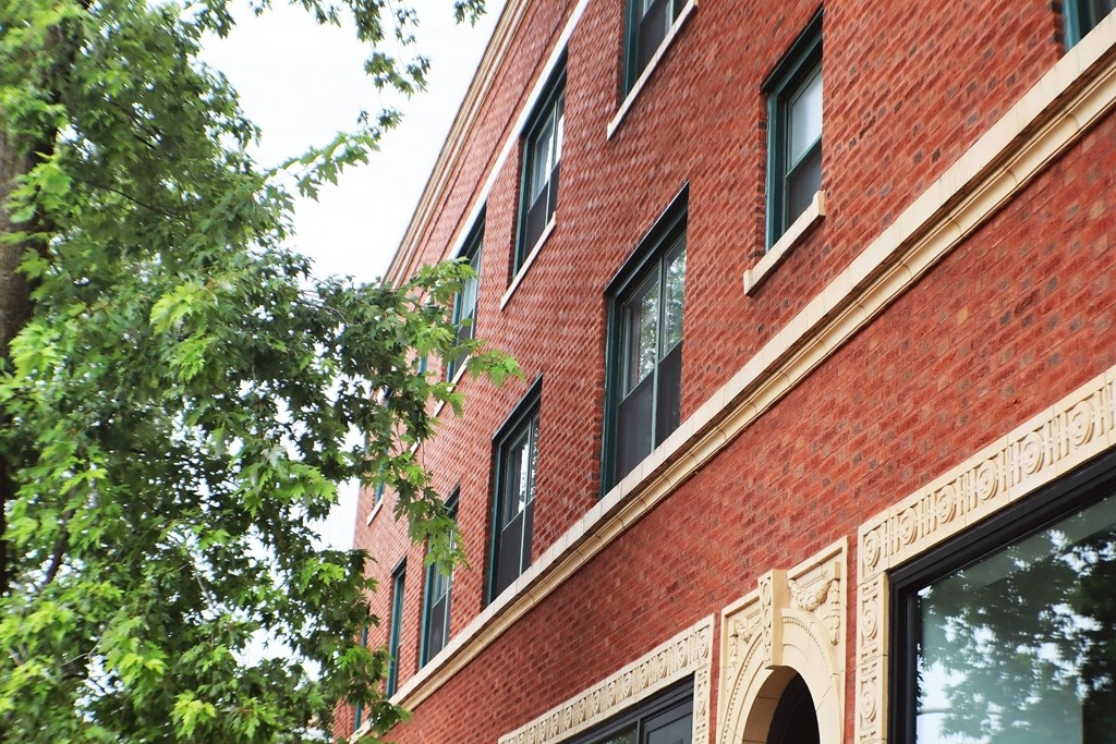 a red brick building with windows and a tree
