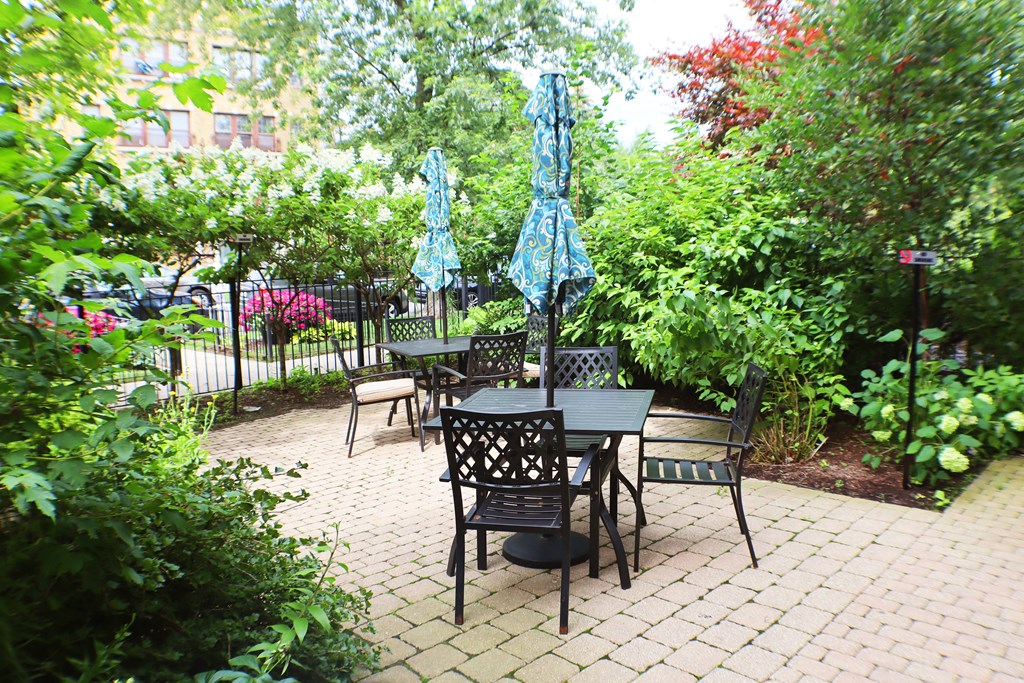 a patio with a table and chairs and umbrellas