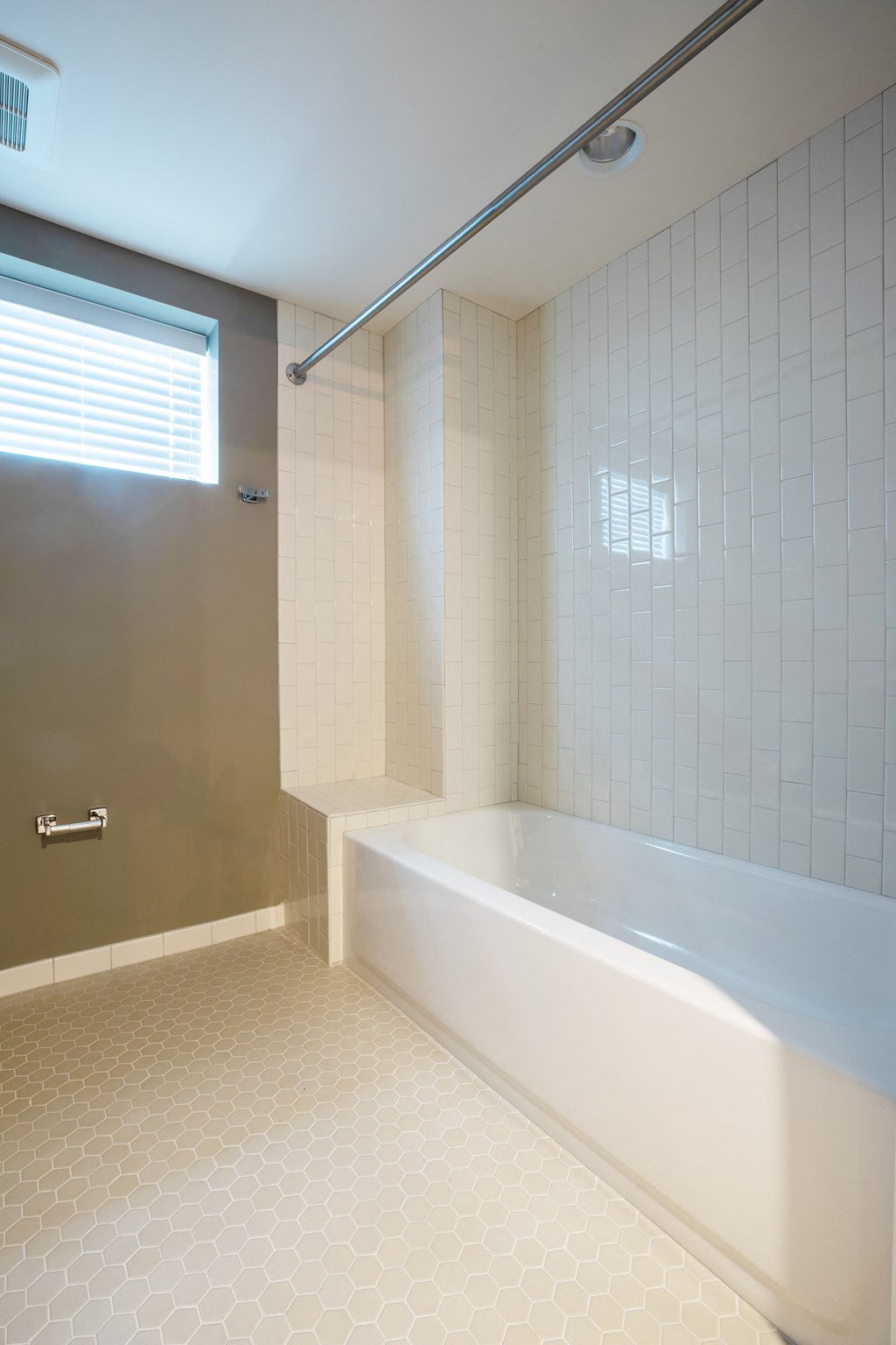 a bathroom with white tile and a white bathtub