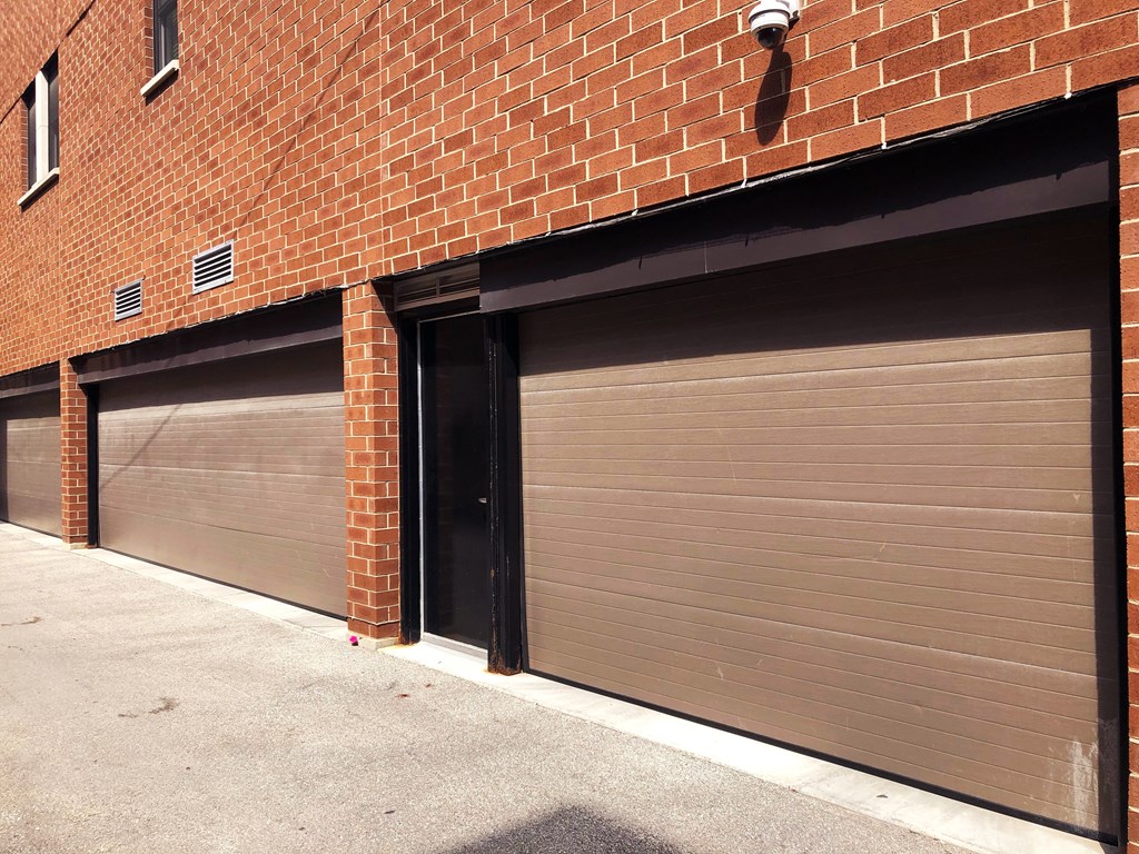 a row of three garage doors on a brick building